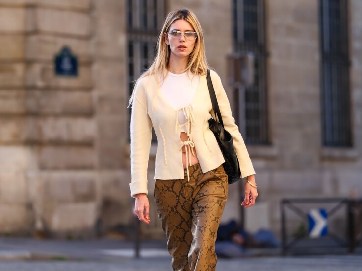 Zu sehen ist eine Frau mit einer gelben Strickjacke und Tiermusterhose