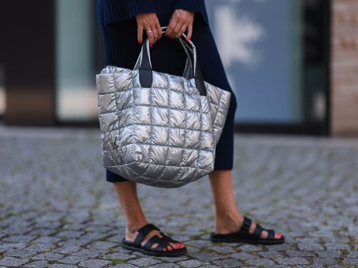 Zu sehen sind Hérmes Sandalen an Frauenfüßen