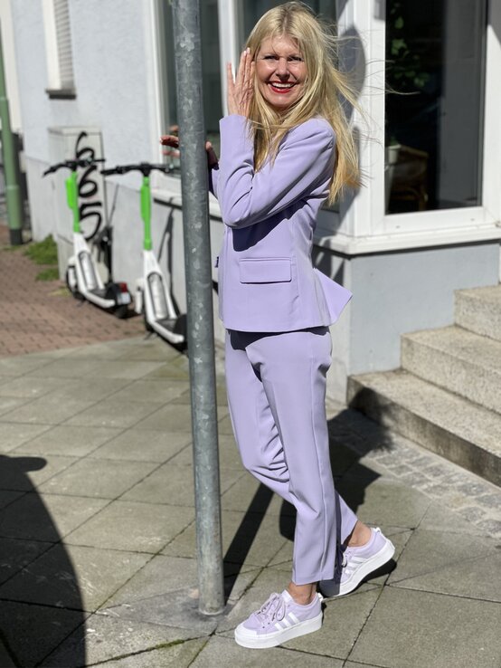 Zu sehen ist Renate Zott in einem lavendelfarbenen Zweiteiler | © Renate Zott