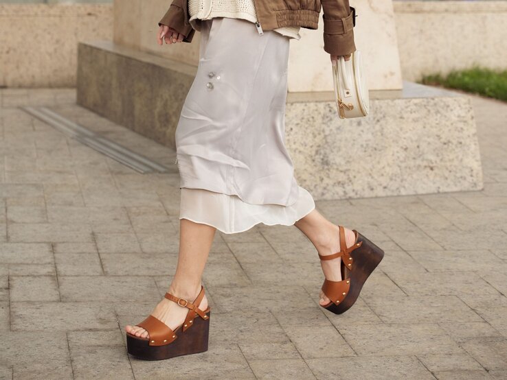 Zu sehen sind braune Wedges und ein weißer Midi Rock