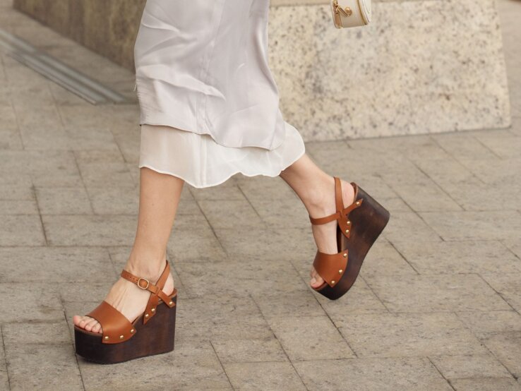 Zu sehen sind braune Wedges und ein weißer Midi Rock