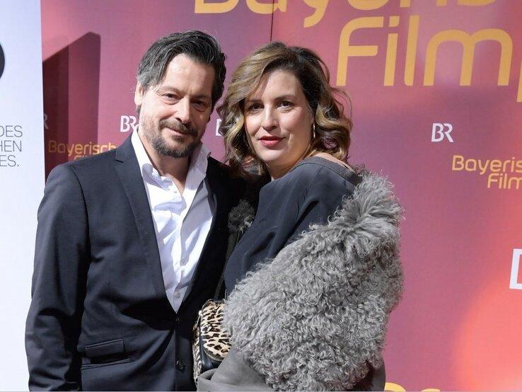 Schauspielerin Elena Uhlig und Schauspieler Fritz Karl stehen bei einer Veranstaltung nebeneinander auf dem roten Teppich