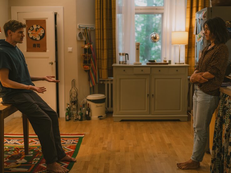Feste Feiern Szene Julia Becker Interview | © Marcus Gaertner/ ZDF "Feste Feiern": Knut (Helgi Schmid) und Karo (Lucie Heinze) stehen sich in der Küche gegenüber. Er lehnt an einem Tisch, sie an der Spüle. | © Marcus Gaertner/ ZDF