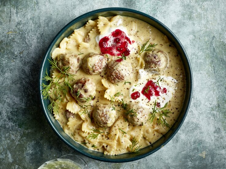 Wenn du Köttbullar und Pasta liebst, wirst du One-Pot-Pasta Köttbullarstyle feiern! In nur einem Topf zauberst du ein cremiges, herzhaftes Gericht, das in wenigen Minuten fertig ist! One-Pot-Pasta Köttbullarstyle in einer dunkelblauen Schüssel auf grauem Hintergrund.