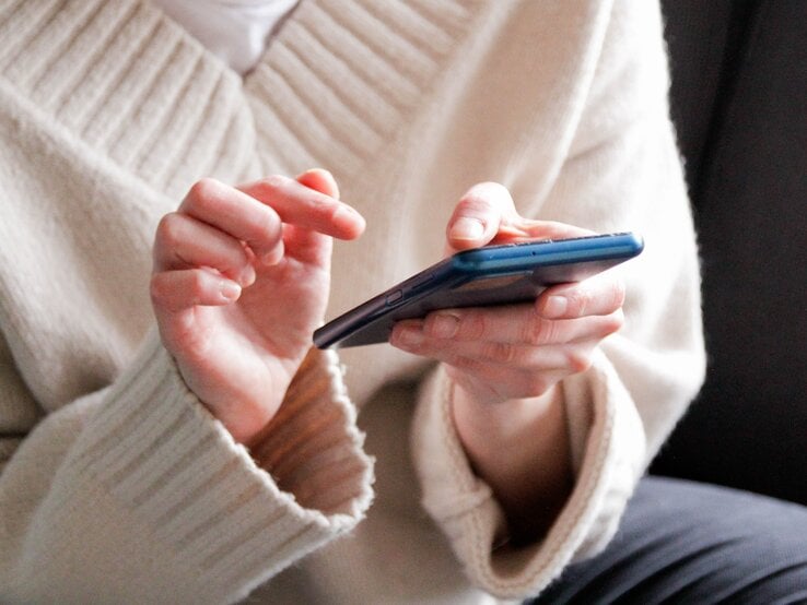 Handy aussortieren Zu sehen ist eine Frau, die ein Handy hält