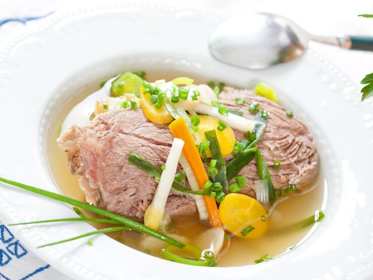 Tafelspitz am Stück / tiefer Teller / Brühe / Schnittlauch geschnitten und am Stück / Möhren in Scheiben und als Stift geschnitten /