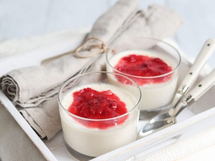  Panna Cotta in Gläsern mit Erdbeersauce, serviert auf einem Tablett.